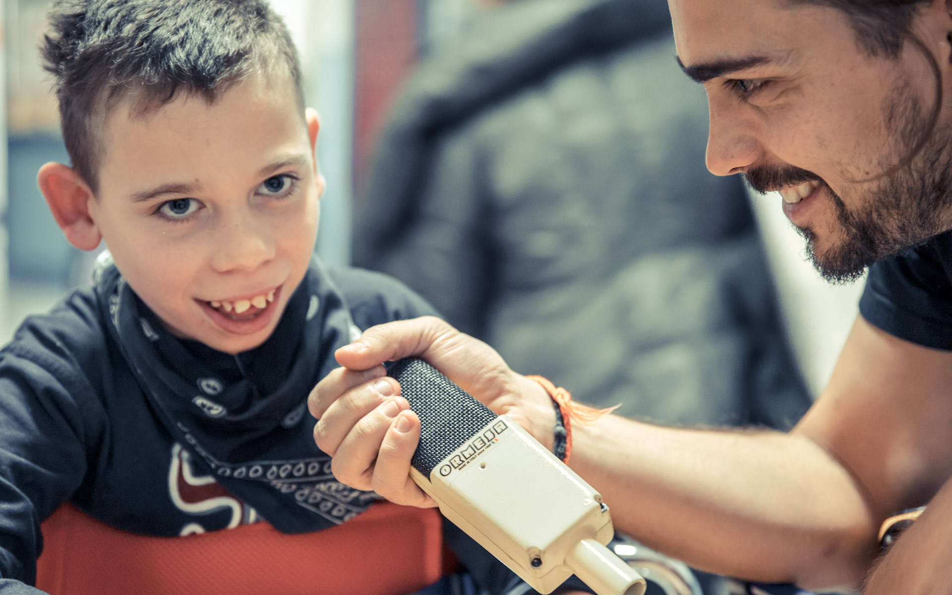 Bambino e insegnante giocano con microfono applicato a App Multisensorial Standing